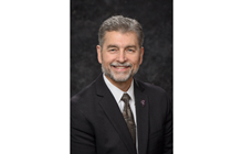 Dr. Juhasz smiles in front of dark gray background.